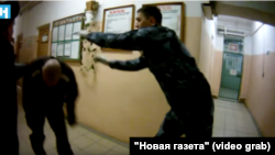 A screen grab from a video released by Novaya Gazeta showing several Russian prison guards forcing inmates to run a gauntlet.