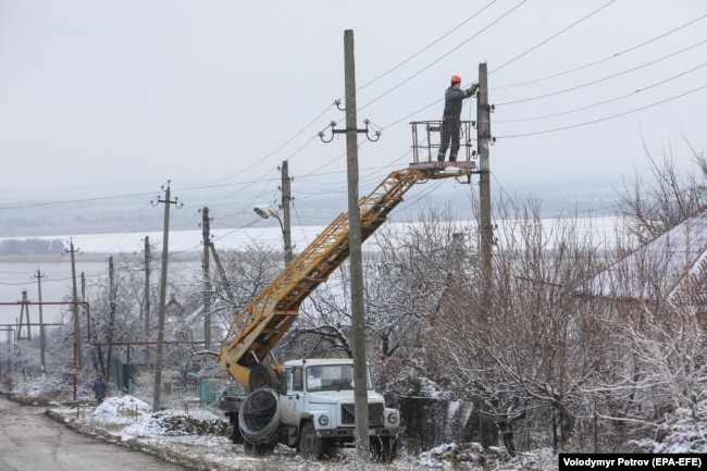 Рабочие восстанавливают линию электропередач в Новолуганском