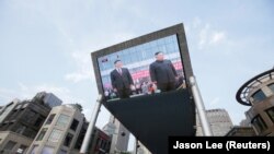 Телевизионный экран на улице Пекина показывает кадры китайского госканала CTV о встрече северокорейского лидера Ким Чен Ына с председателем КНР Си Цзиньпином в Пхеньяне