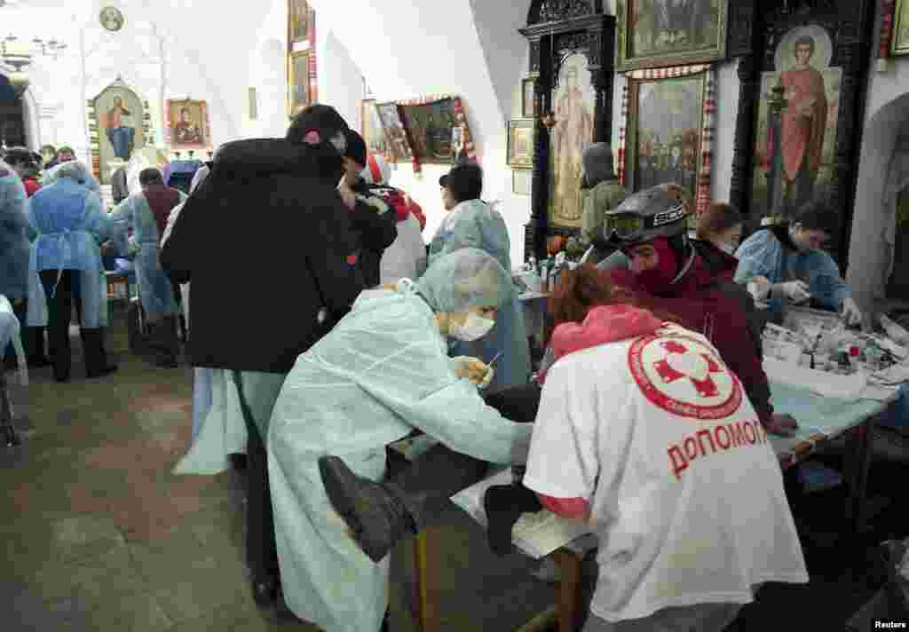 Antigovernment protesters receive medical treatment inside a cathedral in Kyiv on February 19.