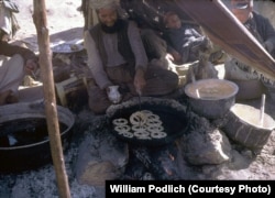 A merchant fries jalebi, a sweet Afghan dessert, over an open fire.