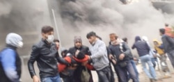 Protesters carrying an injured comrade in Shiraz, Iran