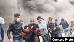 Protesters carrying away a comrade shot during protests in Shiraz, Iran. November 17, 2019