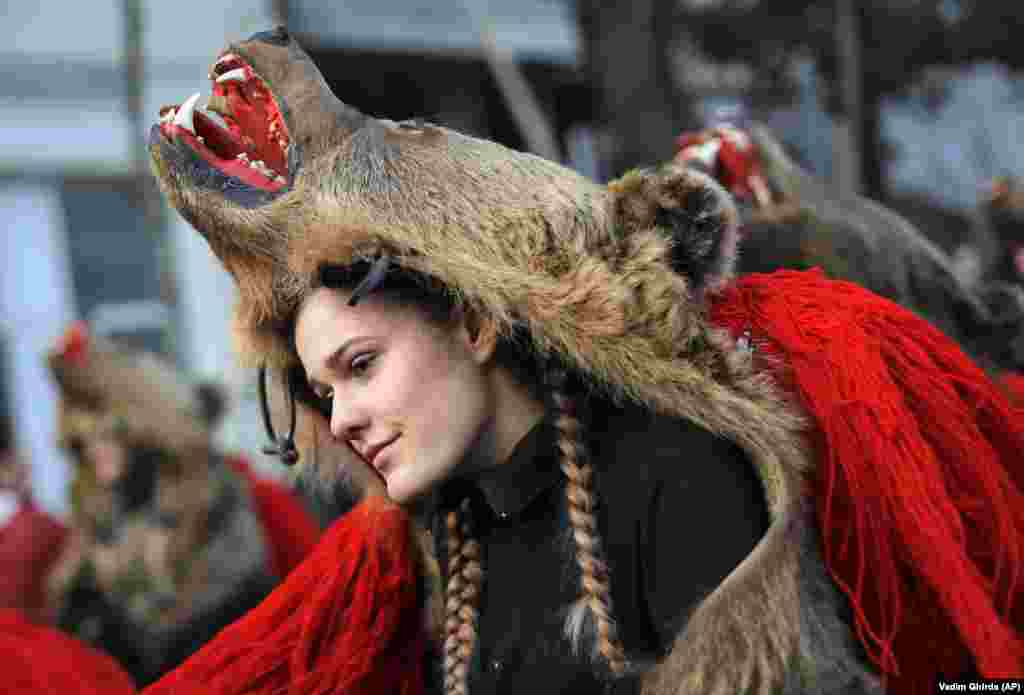A girl wearing a bear costume dances during an annual ritual in Piatra Neamt in northern Romania. The tradition originated in pre-Christian times when dancers wearing colored costumes or animal furs went from house to house in villages singing and dancing to ward off evil. (AP/Vadim Ghirda)