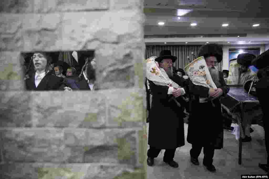 Ultra-Orthodox Jews dance with Torah scrolls in the Mea Shearim neighborhood in Jerusalem during celebrations for Simchat Torah at the close of the Sukkot holiday in Jerusalem on October 1. (EPA-EFE/Abir Sultan)