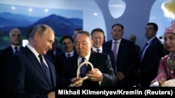 Президент России Владимир Путин и его казахстанский коллега Нурсултан Назарбаев рассматривают камчу на туристической выставке. Петропавловск, 9 ноября 2018 года
