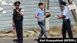 Оқиға маңындағы полицейлер мен журналист. Алматы облысы, Қарасай ауданы, 17 тамыз 2012 жыл.