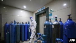 Співробітник госпіталю в місті Ухань, Китай, у приміщенні для зберігання балонів із киснем