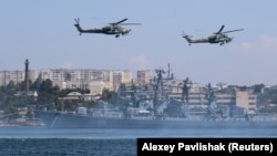 Elicoptere militare rusești zburând deasupra Mării Negre la Sevastopol, under se află cea mai mare bază militară din regiunea pontică