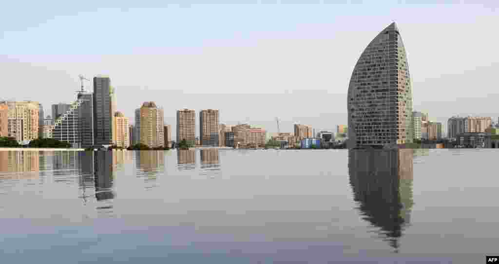 The Baku skyline is reflected in a fountain, June 10, 2015. 