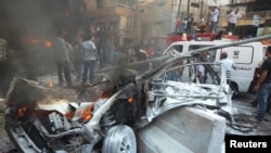 A destroyed car is seen at the site of an explosion in Beirut's southern suburbs on August 15.