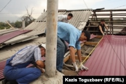 Civil society activists perform repairs on Atabek's home in September 2012.