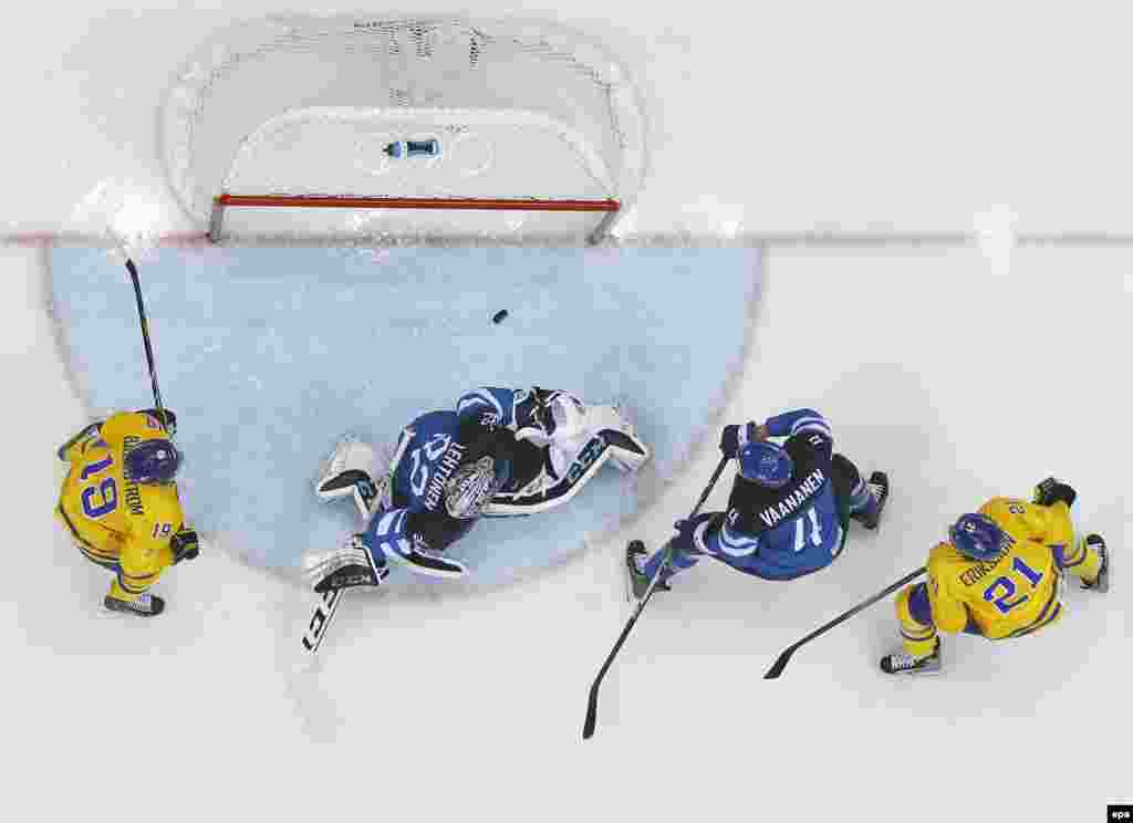 Sweden&#39;s Loui Eriksson (left) and Nicklas Backstrom and Finland&#39;s Ossi Vaananen and goalie Karl Lehtonen watch the puck going over the bar during the semifinal between Sweden and Finland. (epa/Larry W. Smith)