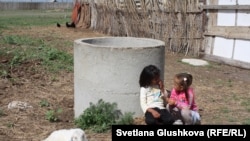 Ауру лақтың қасында ойнап отырған балалар. Қостанай облысы Қабырға ауылы, 8 маусым 2015 жыл.