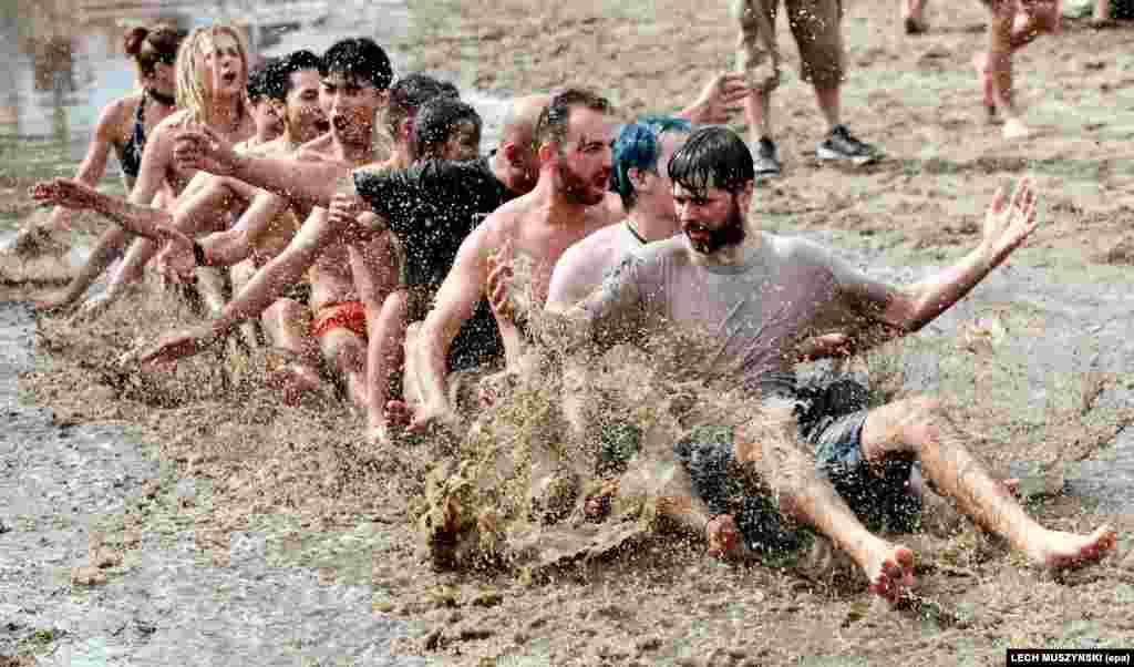Festivalgoers take part in the traditional mud bath on the first day of the 23rd Przystanek Woodstock (Woodstock Bus Stop) festival in Kostrzyn nad Odra, Poland. (epa/Lech Muszynski)