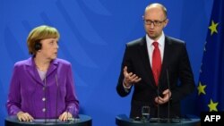 German Chancellor Angela Merkel (left) listens to Ukraine's Prime Minister Arseniy Yatsenyuk during a joint press conference after talks in Berlin on May 28.