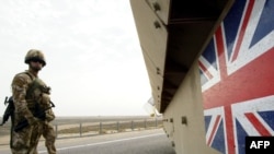 British soldiers keep watch as a tank drives near the airport in Basrah in 2007.