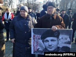 Mikhail Zhyzneuski's parents hold a photo of him at an event in Minsk in March 2016.