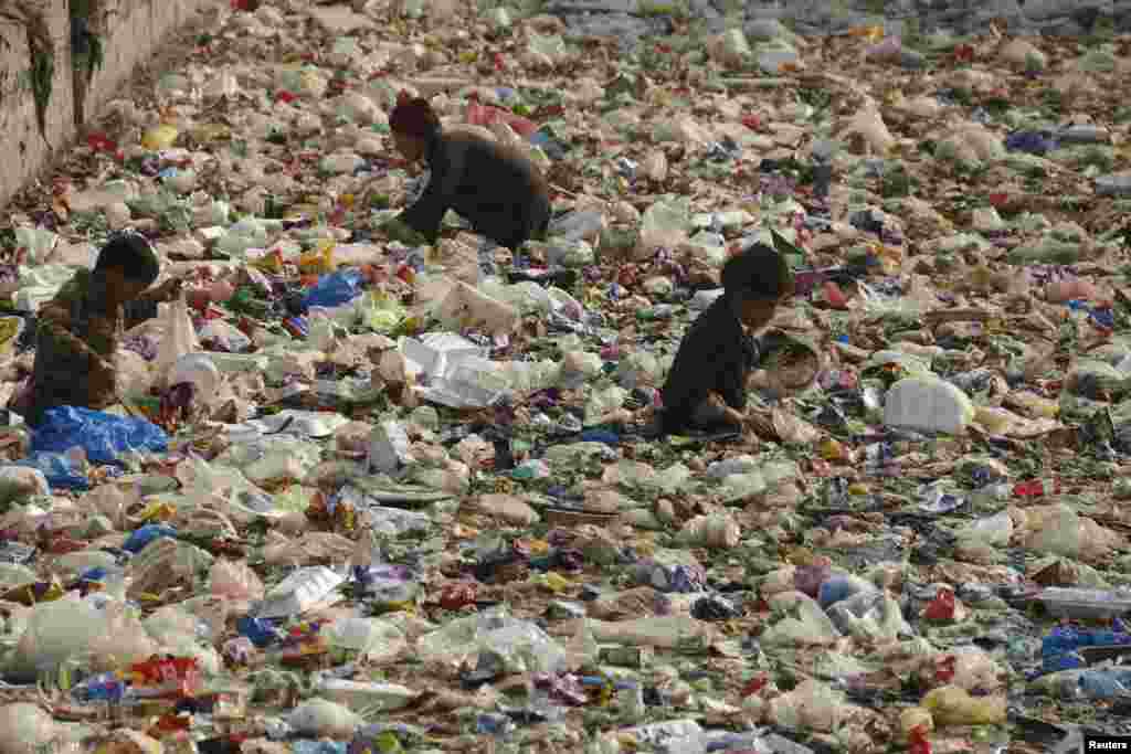 Fëmijët duke kërkuar për plastikë të riciklueshme në një kanal në Peshawar, Pakistan.