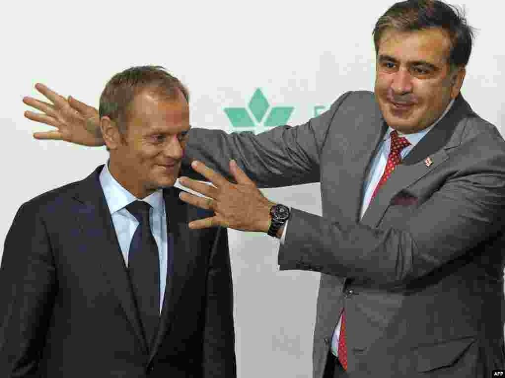 Premierul polonez Donald Tusk (stânga) şi preşedintele georgian Miheil Saakaşvili conversează înaintea unui dineu la summitul Partneratului Estic de la Varşovia. (AFP/Janek Skarzynski)