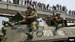 Russian forces pass by Georgian protesters in the city of Poti during the Georgia-Russia conflict in August 2008. 