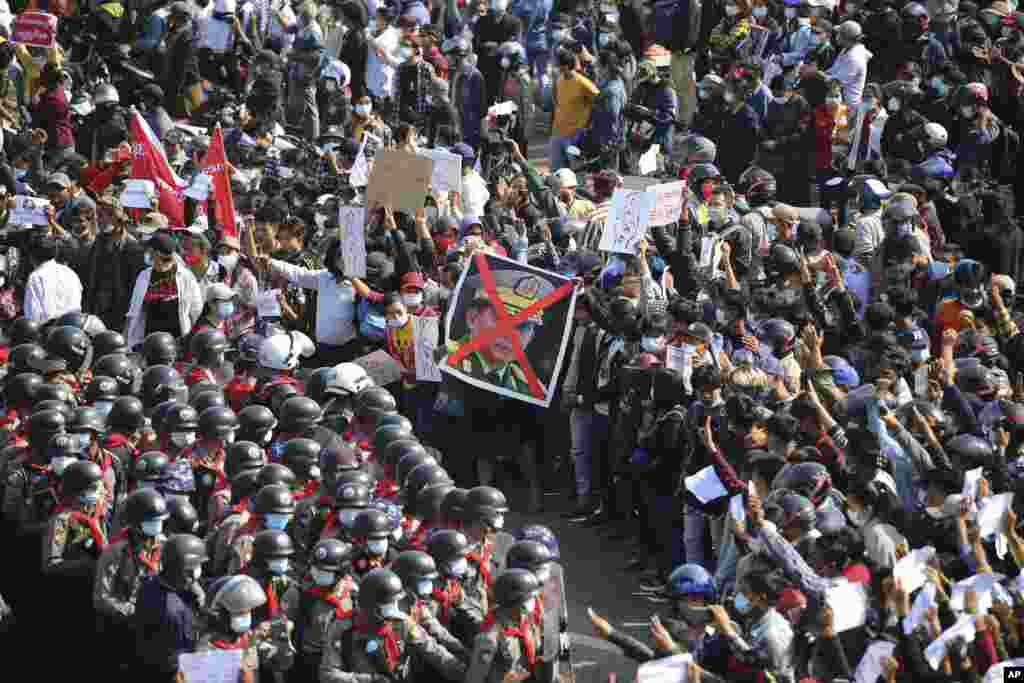 Protestues duke përshëndetur me tre gishta dhe duke mbajtur një foto me një shenjë X në fytyrën e komandantit të Përgjithshëm të Ushtrisë së Mianmarit, gjeneralit Min Aung Hlaing. 8 shkurt, 2021. (AP)