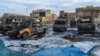 A picture taken with a mobile phone shows burnt vehicles at the scene of a blast from a massive car bomb, which killed scores of people in Baghdad on February 16. 