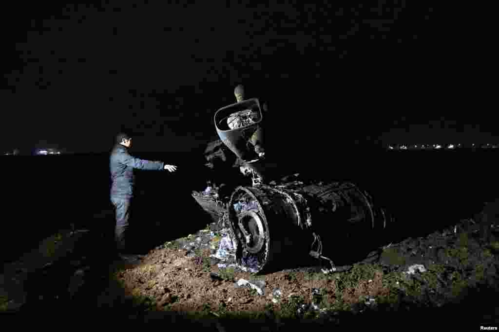 A television reporter points at the wreckage of a Turkish Air Force F-16 fighter jet after it crashed in an empty field in the southeastern city of Diyarbakir. The pilot ejected safely. A technical fault is being blamed. (Reuters/Sertac Kayar)