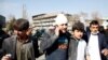 People assist an injured man after a blast in Kabul on January 27.