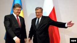 Президент Польши Бронислав Коморовский (справа) приветствует президента Украины Петра Порошенко
