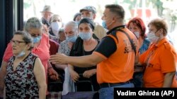 Security personnel control access to a food market in Bucharest on July 1. Romanians, mostly elderly, waited from the early morning hours to get into the market, which was refurbished after being closed during the lockdown.