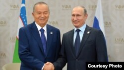 Islam Karimov and Vladimir Putin shake hands in 2015.