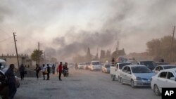 SYRIA -- Syrians flee shelling by Turkish forces in Ras al Ayn, northeast Syria, Wednesday, Oct. 9, 2019. 