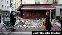 Люди стоят у ресторана Le Carillon, на который было совершено нападение. Париж, 16 ноября 2015 года.