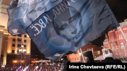 Supporters wave Putin banners on Manezh Square in Moscow soon after the polls closed on March 4, with election officials suggesting Vladimir Putin had enough votes to avoid a second-round runoff for the presidency.