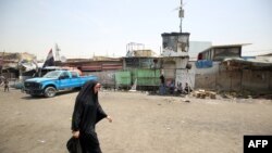 An Iraqi woman walks at the Oraiba market in Baghdad's Sadr City on May 12, 2016, a day after it was struck by a car-bomb attack.