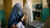 Afganistan -- An Afghan burqa-clad woman casts her vote inside a polling centre in Kabul, 20Aug2009