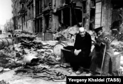 Слепой человек (справа) и его проводник на берлинской улице, 1945 год. Халдей вспоминал, что спросил слепого на немецком: «Откуда вы?». Тот ответил: «Мы больше не знаем. Мы не знаем, откуда мы и куда мы направляемся».