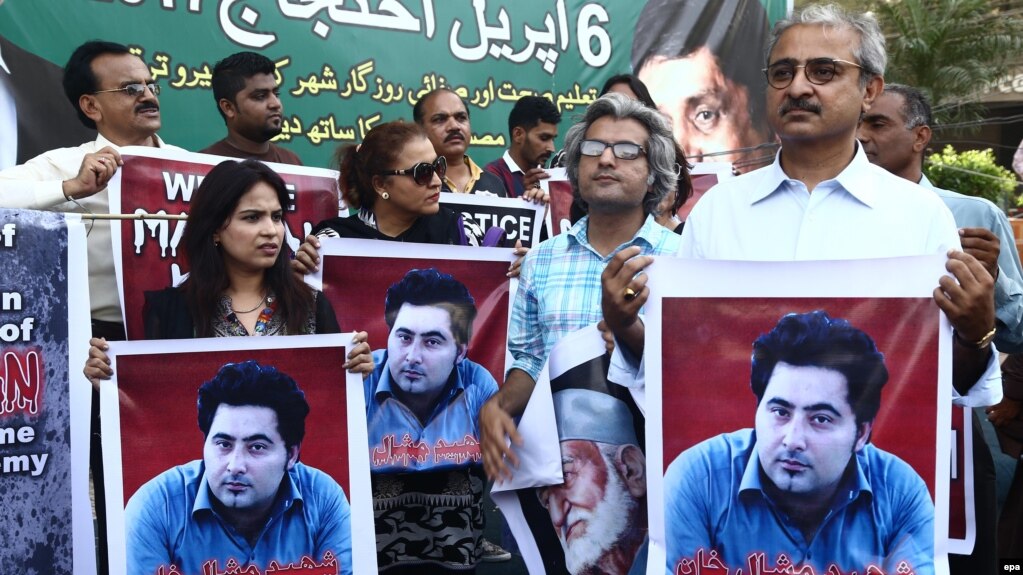 During a rally in Karachi, people hold portraits of Pakistani student Mashal Khan, who was killed by a mob for alleged blasphemy at Abdul Wali Khan University in April.