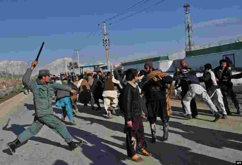 An Afghan policeman uses his baton to disperse demonstrators during a Kabul protest on February 24.