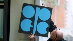 Робітник прикріплює плакат Організації країн-експортерів нафти (ОПЕК) в їхній штаб-квартирі у Відні, листопад 2017 року