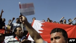 Demonstrators hold a Bahraini flag to denounce a crackdown on Shi'ite-led demonstrators in Bahrain in Baghdad on March 18.