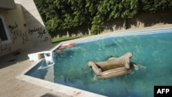 An armchair and furniture float in the swimming pool of the U.S. consulate in Benghazi following an attack on the building in September 11 in which the US ambassador to Libya and three other US nationals were killed.