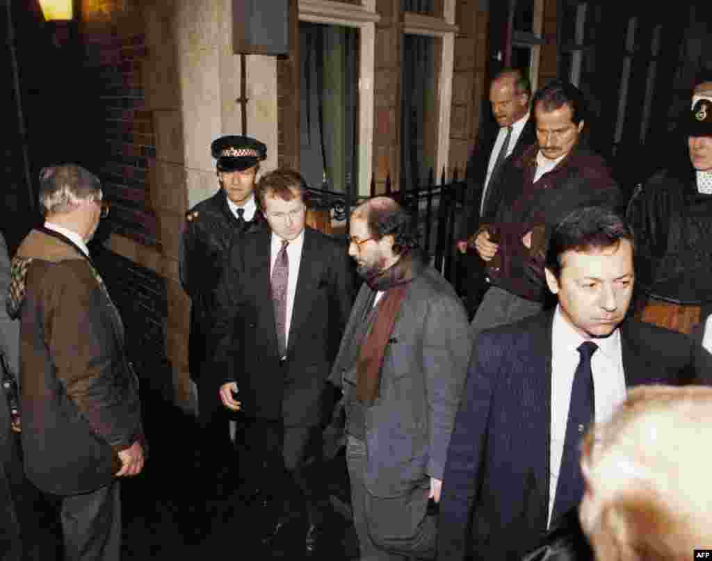 Salman Rushdie (center), surrounded by police and bodyguards, leaves London&#39;s Stationers Hall by a rear exit in February 1992.