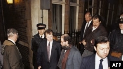  Салман Рушди напуща схрада в Лондон през заден излаз и заобиколен от полиция и защита, 14 февруари 1992 година, третата годишнина от фетвата. 