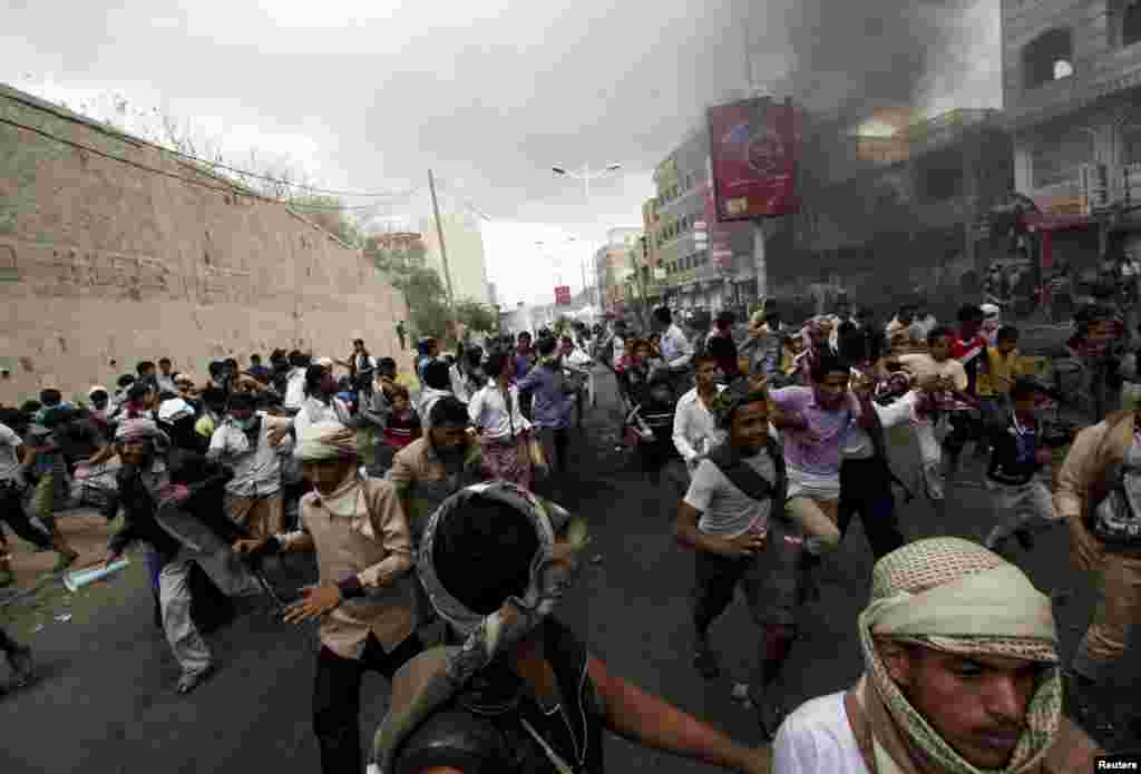 Anti-Houthi protesters flee as police open fire in the air to disperse them in the southwestern Yemeni city of Taiz on March 23. (Reuters/Anees Mahyoub)