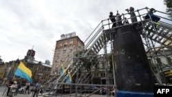 People take photos atop the the pedestal of the former Lenin monument after the opening of the installation in Kyiv on July 9.