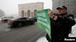 Мужчина держит плакат во время митинга, организованного активистами политической партии «Яблоко» в поддержку Светланы Давыдовой возле штаб-квартиры ФСБ в центре Москвы. 3 февраля 2015 года.