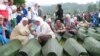 Bosnian women cry over the coffins of relatives, set to be reburied in Potocari, near Srebrenica.