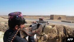 Afghanistan -- An Afghan Local Police (ALP) personnel keeps watch during an ongoing battle with Taliban militants in the Marjah district of Helmand Province on December 23, 2015.